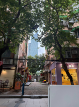 Older residential buildings framing Guangzhou high-rises